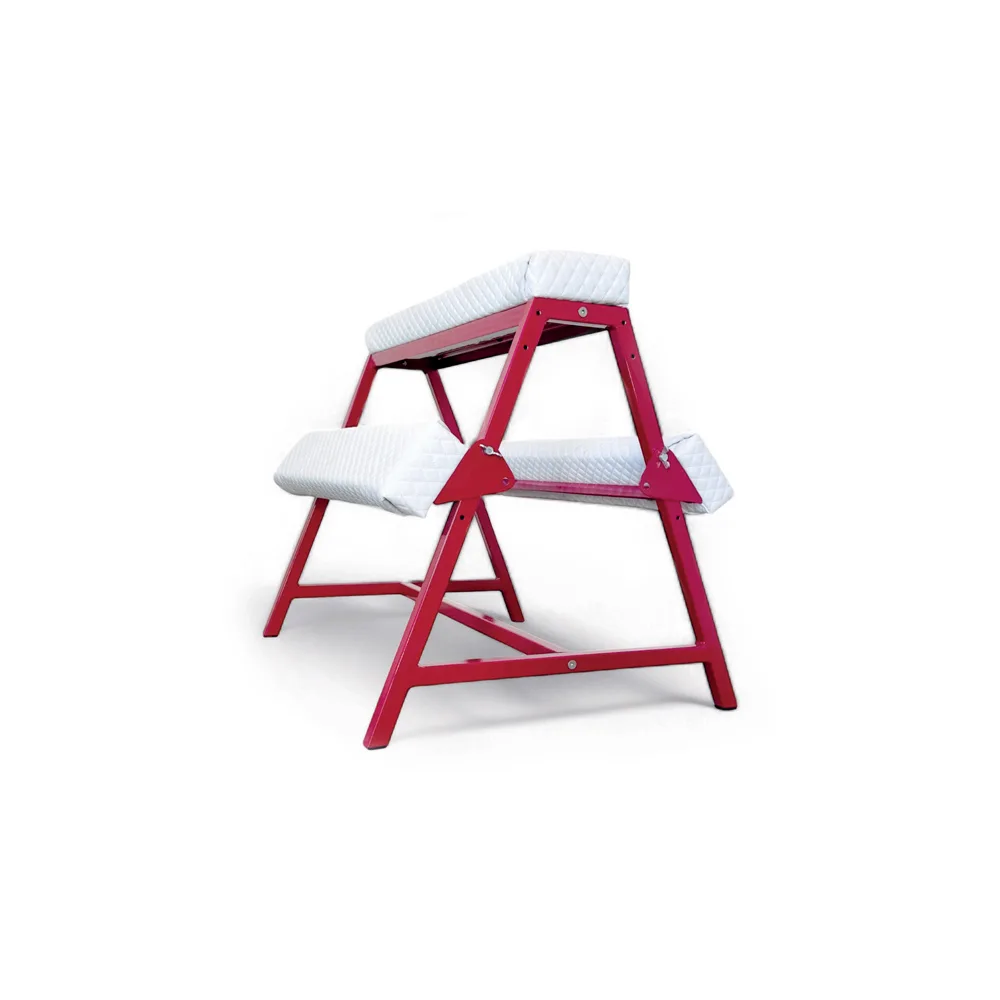 Mobilier BDSM : Banc à féssées rouge et blanc avec une personne dessus.